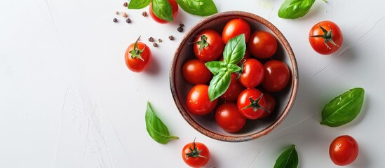 Fototapeta premium Top view of cherry tomatoes green basil and tomato sauce in a bowl on a white background with copy space image