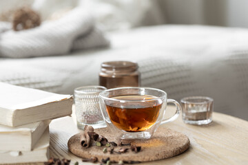 Still life with a cup of tea, books and a candle in a candlestick.