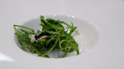 Prepare salad from leaves. closeup of a spurt of olive oil falling on a mix of different salad leaves, like romaine lettuce, endive or arugula, on a rustic metal dish