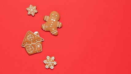 Christmas gingerbread cookies on red paper background, top view, flat lay, banner.