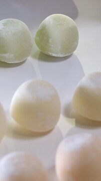 Photos of motti of different colors with different fillings isolated on white background, a delicious colored dessert.