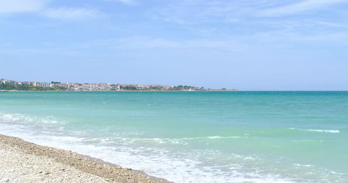 Bright day along the Gerze coastline in Sinop with turquoise water and the seaside town in the distance. 4K UHD.