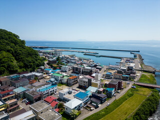 Obraz premium Rausu, Hokkaido: Aerial drone view of the Rausu town and harbor in the Shiretoko peninsula in Hokkaido in summer in Japan