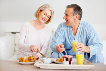 Mature couple, smile and breakfast together on sofa with bonding, diet nutrition and support in home. Happy, man and woman with morning meal, healthy food and romantic time for love relationship
