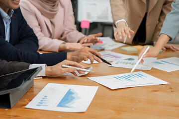 Group of Asian business men and women sitting and looking at documents at the office.