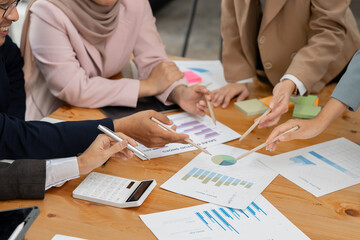 Group of Asian business men and women sitting and looking at documents at the office.