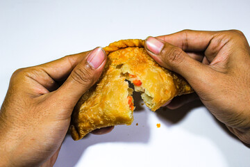 Traditional Indonesian fried food called pastel cake, which is torn open with two hands