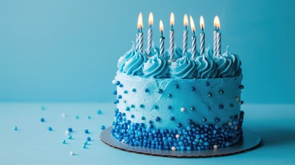 Blue themed birthday cake with candles on blue backdrop