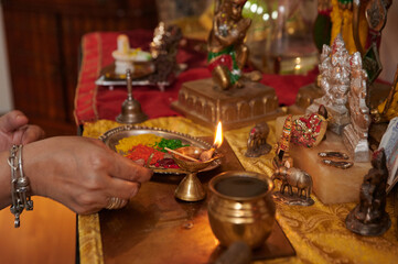 Close-up of Indian mature woman praying at altar