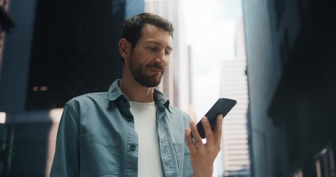 A Man Uses an AI Assistant on His Smartphone for Tasks Like Chatting, Searching, and Getting Support While Walking Through a City Street. Person Uses Artificial Intelligence Technology