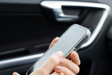Female hands with a phone close-up. Fingers with a mobile phone. Phone in the car. Correspondence, video call