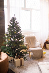 Home New Year's interior. Christmas tree with gifts, decorated with garlands. Cozy atmosphere of a home holiday, loft design of the room, Scandinavian style
