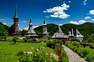 Barsana wooden church (left) and monastery complex with romantic sky in Barsana, Maramures, Romania
