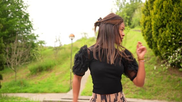 Side view of a cute brunette woman dancing cuban salsa alone outdoors