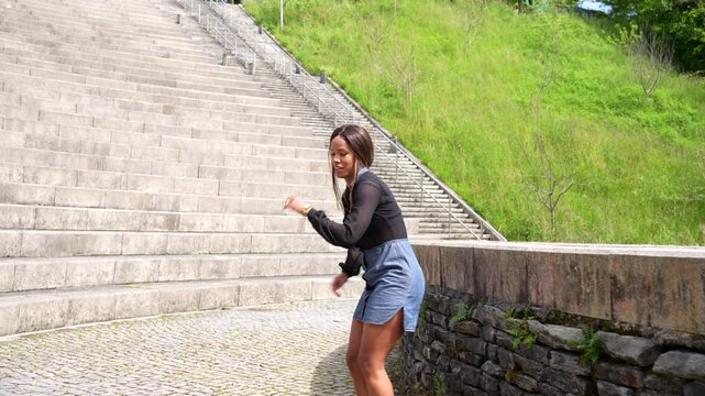 Joyful smiling cuban young and beauty woman dancing salsa in a park