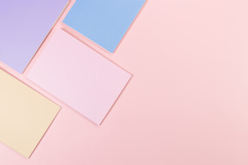 Top view of pink, purple, blue and beige notebooks on pink background. School, office wallpaper. Flat lay, copy space.