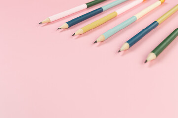 Top view of colorful pencils on pink background. School, office, art wallpaper. Flat lay, copy space.