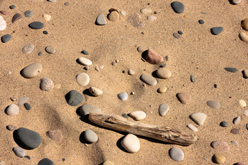 Lake Michigan created the mosaic of beach sand, mulit-colored stones, driftwood and foot prints in the beach at Kohler-Andrae State Park, Sheboygan, Wisconsin in mid-March