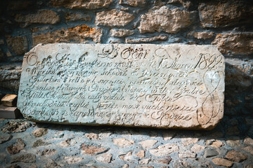 Ancient Inscribed Stone Tablet with Detailed Cursive Writing in Historic Setting