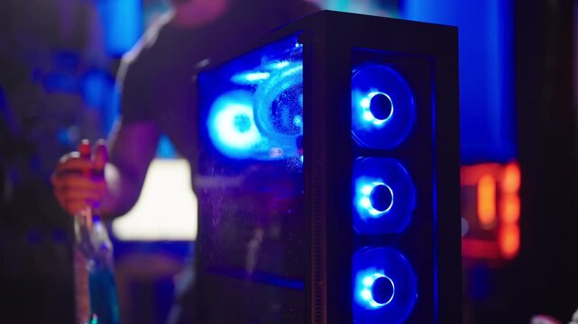 Person cleaning glass side panel of RGB gaming computer 4K