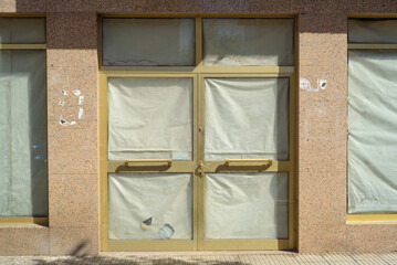 Puerta cubierta de papel en escaparate de tienda cerrada