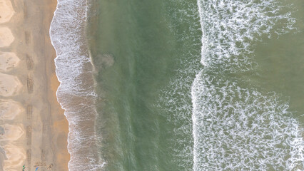 Aerial view of the coast with beaches and white waves of the sea.