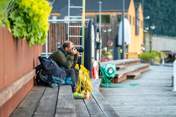 a male landscape photographer at work in Andlasnes Norway Rauma region, photographing the sunrise...