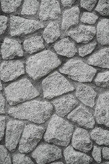 Empty monochrome black and white (light gray) embossed stone wall for abstract background and texture for interior or exterior design. Beautiful patterns, space for work, banner, wallpaper Vertical.