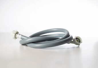 Gray twisted water hose from a washing machine on a white background, isolate, close-up