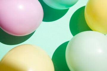 Mint green background with pink, yellow and white air balloons and copy space, frame design element