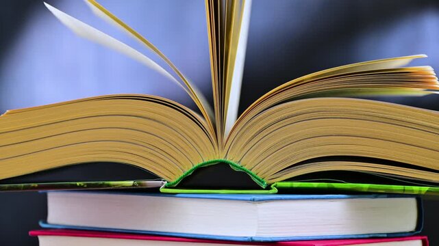 An open book lying on a stack of other books
