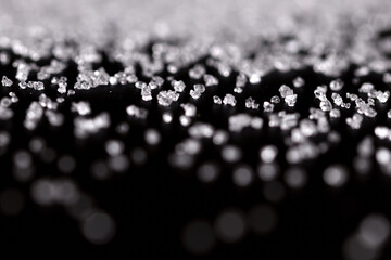 Extreme macro photography of white crystal sugar isolated on black background