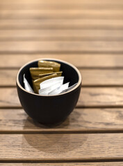 Few bags of white and brown sugar on a wooden coffee table in a cafe