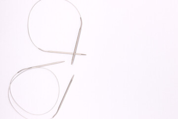 Knitting needles on a blue background. Hobby accessories with copy space.