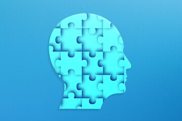 Human head made of jigsaw puzzle on blue background