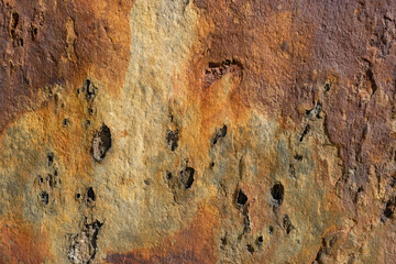 Antique wall texture with a weathered finish, irregular surface in various shades of ochre