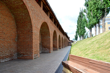 a brick fortress with a red brick wall and some green trees 