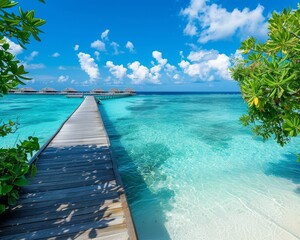 Fototapeta premium A wooden walkway leads to a tropical island with crystal clear turquoise water and lush green foliage. The blue sky is dotted with fluffy white clouds.