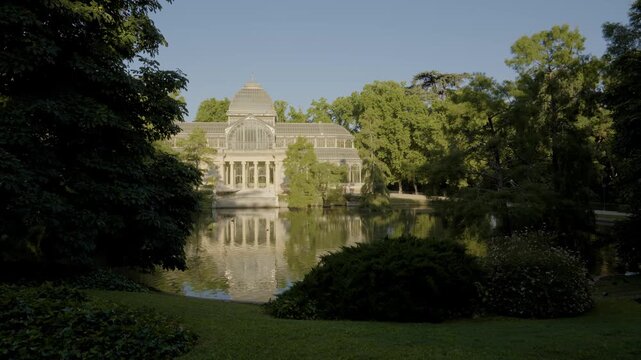 Retiro Park Glass Palace Madrid, Spain Sunrise. View Over the Water with No People Blue Sky Bright Light Trees Gardens in European City Landmark.