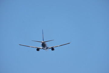 Airplane in Flight Viewed from Behind Against Clear Sky