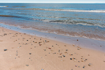 Washed up along the Lake Michigan shoreline, small stones accumulate on the beach at Kohler-Andrae State Park, Sheboygan, Wisconsin