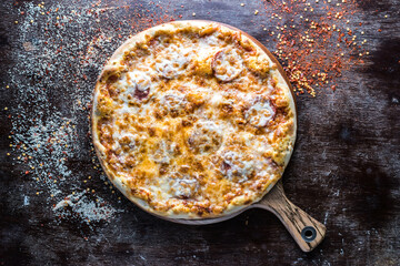 Peperoni Pizza served in wooden board isolated on dark background top view of italian fastfood
