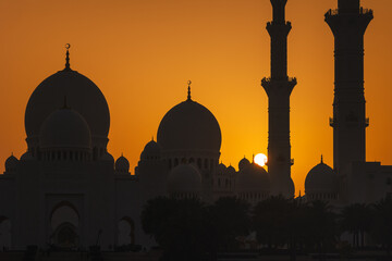 View of Grand Mosque in Abu Dhabi during very nice sunset. Beautifull warm colors on the sky.