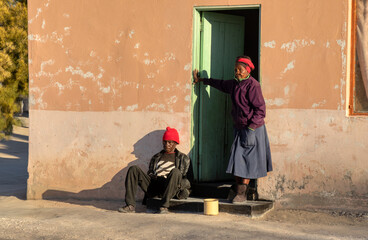 village old african couple waiting in the sun in front of the house