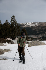 Skier stands on the snow against the background of a high mountain