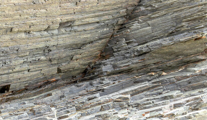 Layered rock formation with distinct horizontal lines and textures