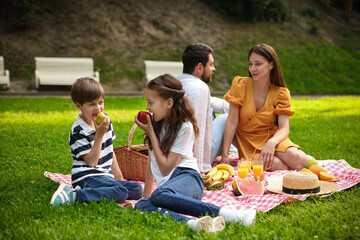 Lovely family having picnic together in park