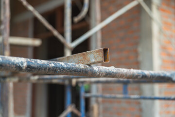 Close-up at metal scaffolding structure at the housing construction building site. Industrial working equipment object photo, selective focus.