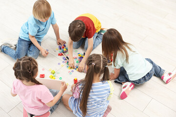 Group of children playing together on floor indoors