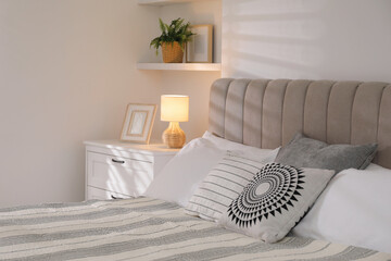 Stylish contemporary bedroom interior with houseplant and comfortable bed